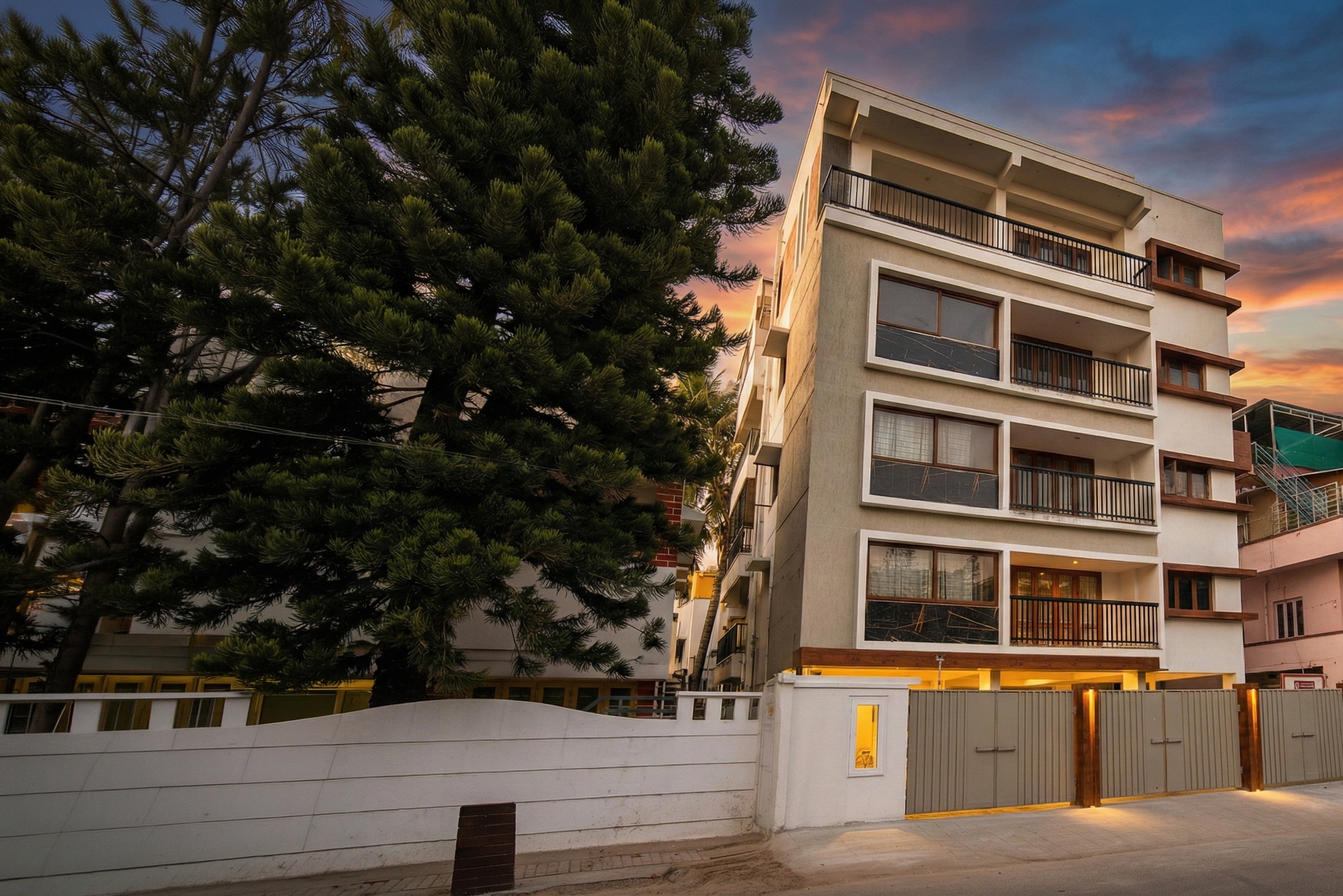 Modern white concrete building facade with greenery